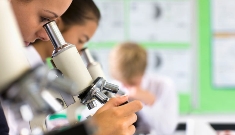person looking into microscope
